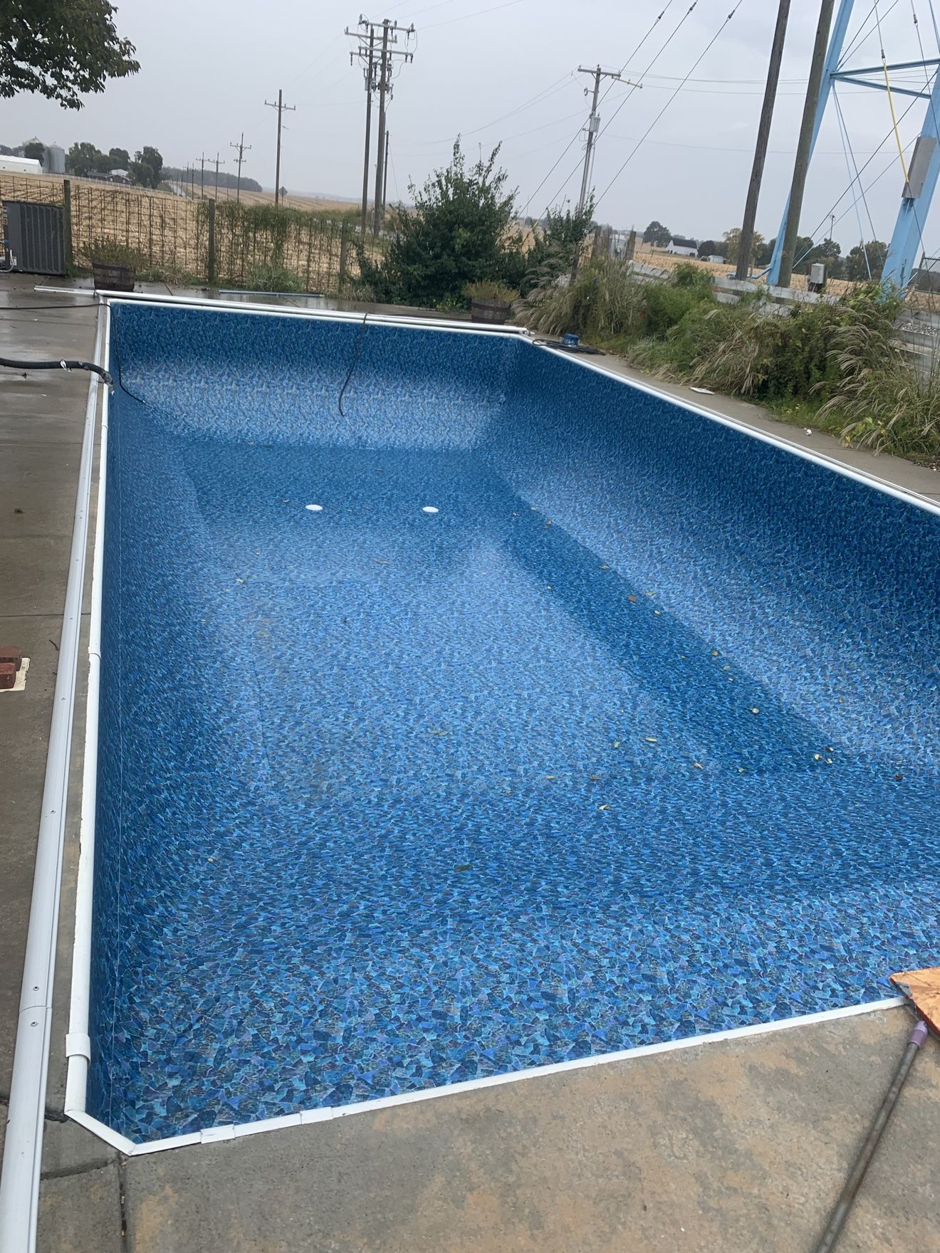 New blue patterned vinyl liner fitted wall to wall in an empty inground pool