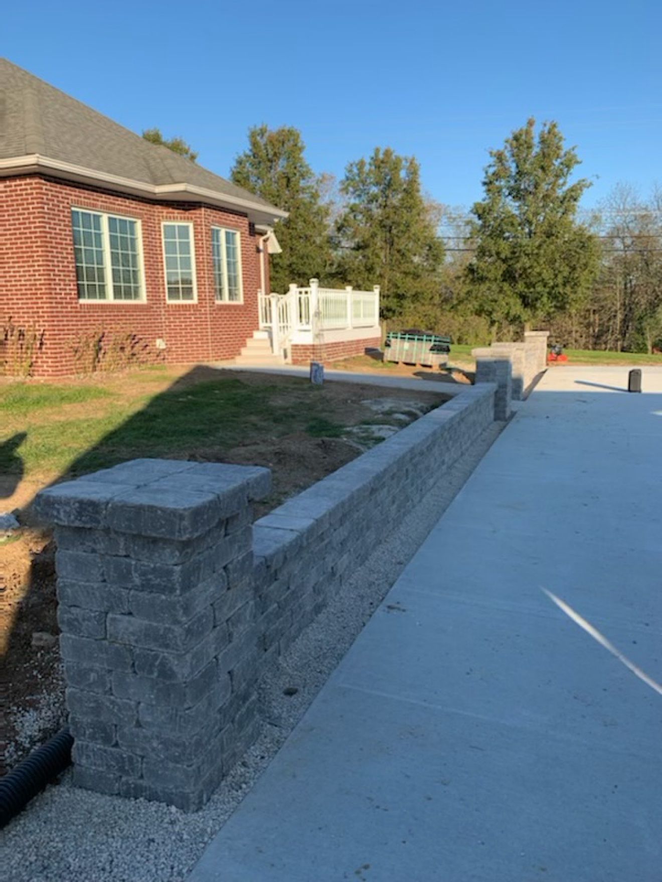 Close-up of a gray block retaining wall and pillar along a concrete deck