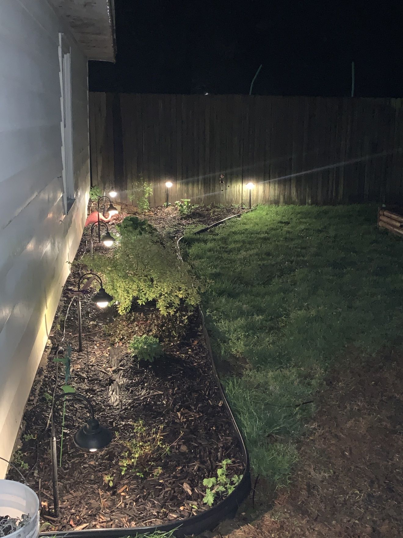 Whole house at night with lighted landscape beds around it